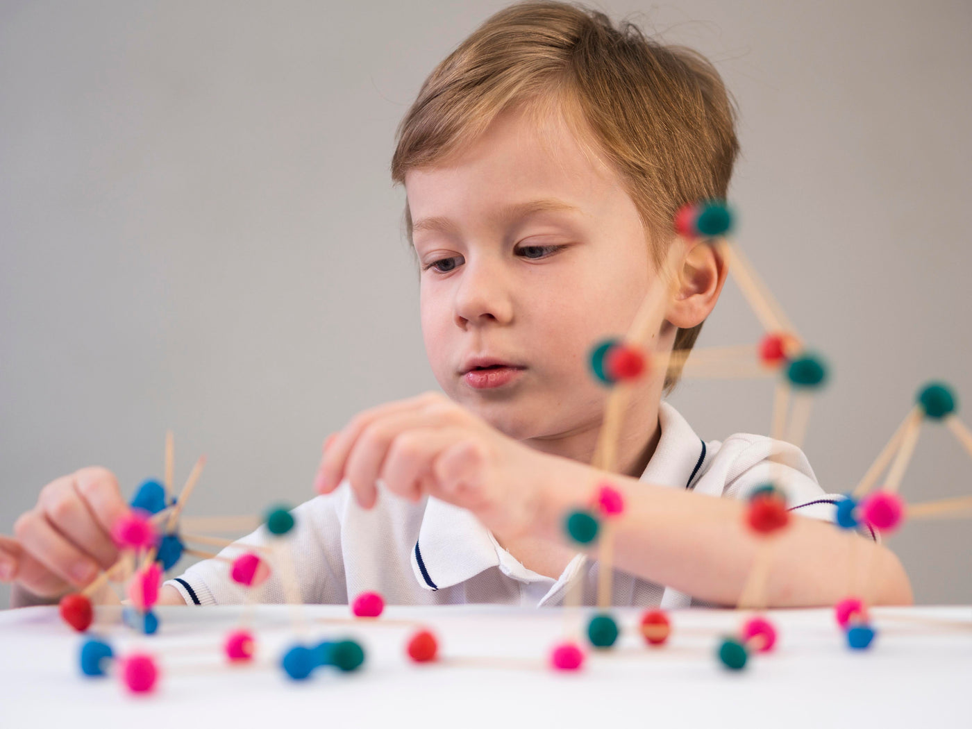 Kid playing with pasta sticks Montessori play