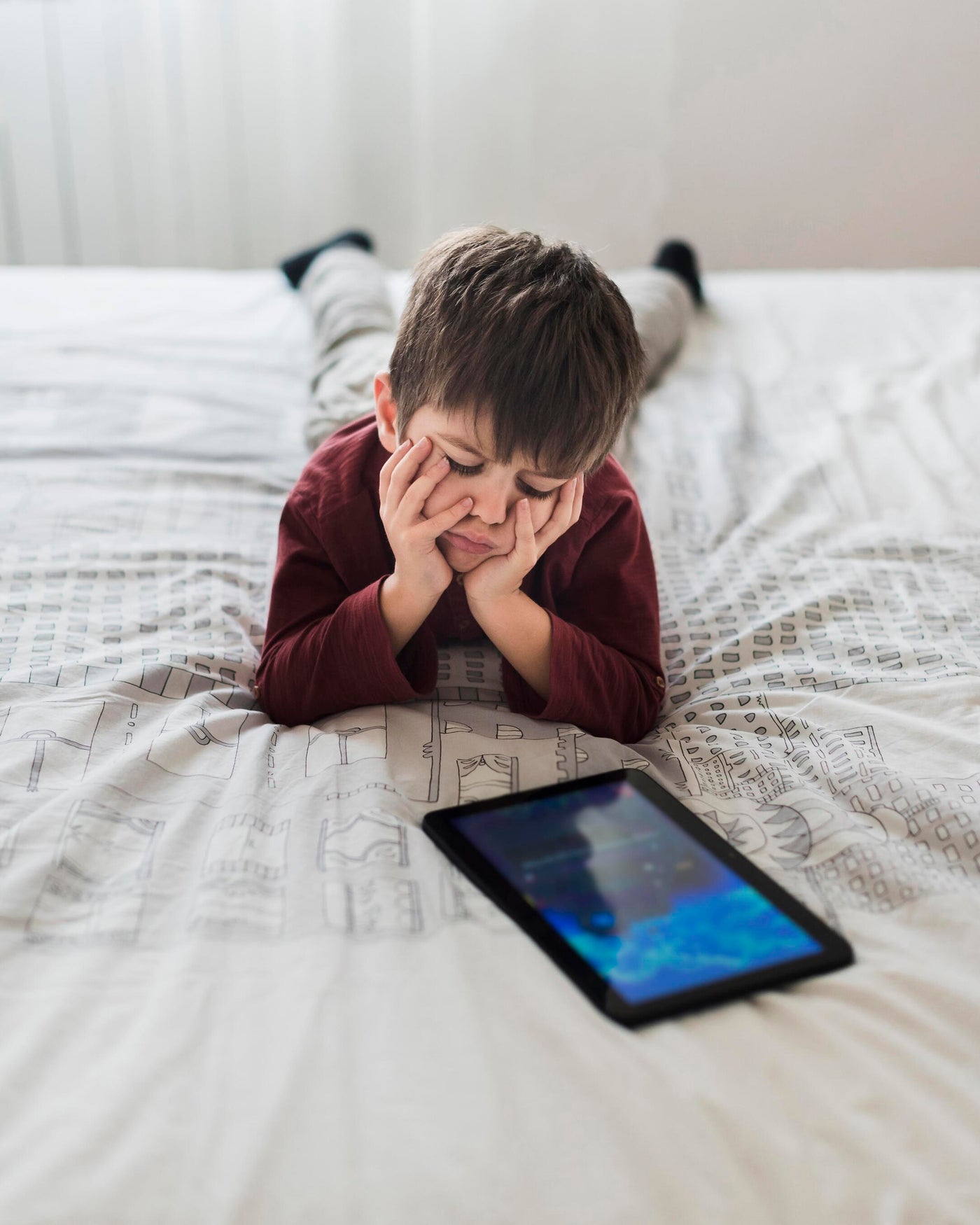 Child Looking at Tablet being frustrated. Montessori method Offering Solution